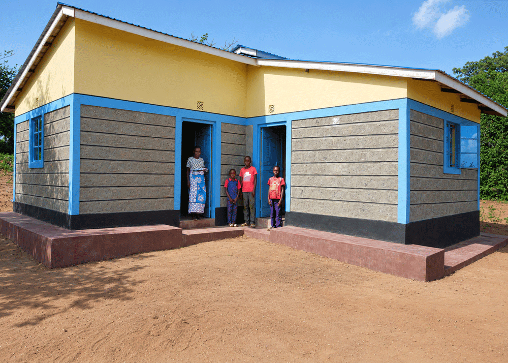 Brian and his family with a new house in Kenya