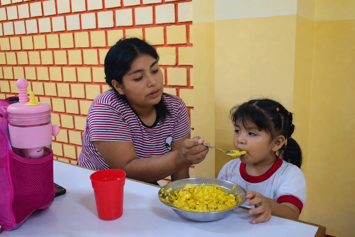 A mom feeding her daughter in Peru
